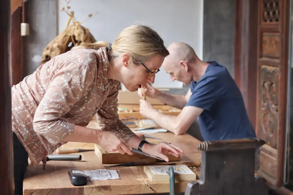 Two guests taking part in a hands-on woodworking workshop in Jianchuan, Yunnan.