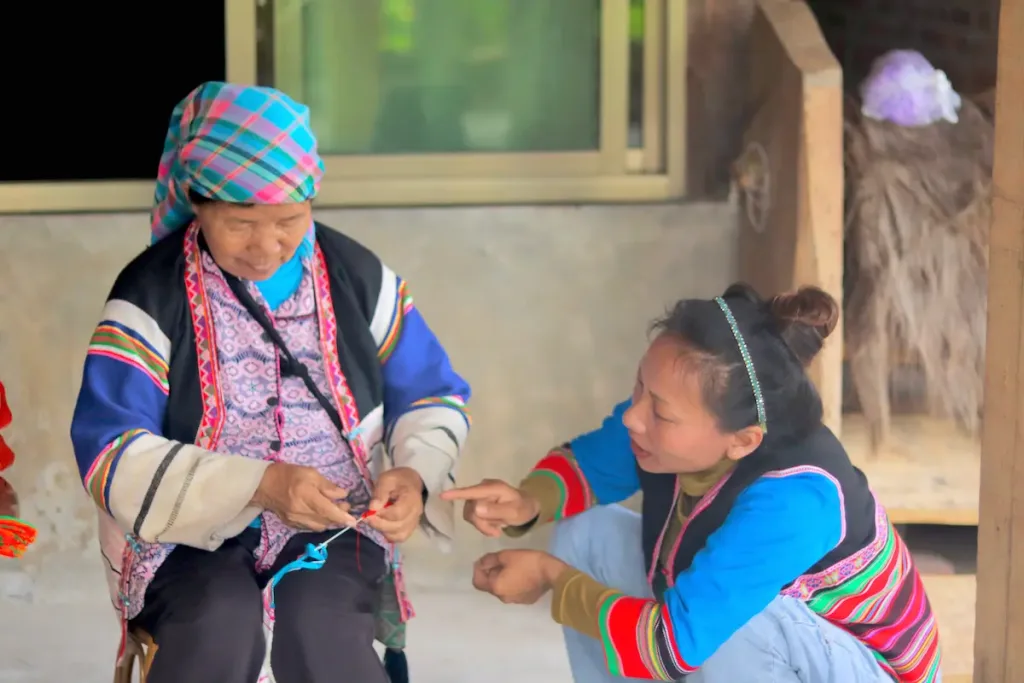 A Jinuo mother and daughter doing traditional craftwork together.