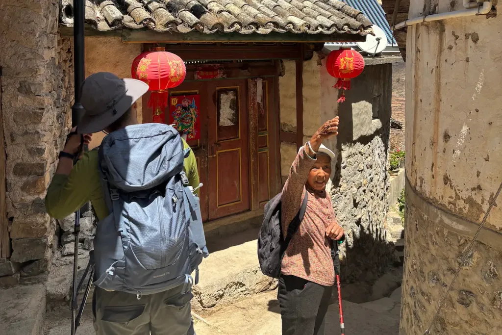 A Naxi female village guide in Lijiang talking to a guest from the United States.