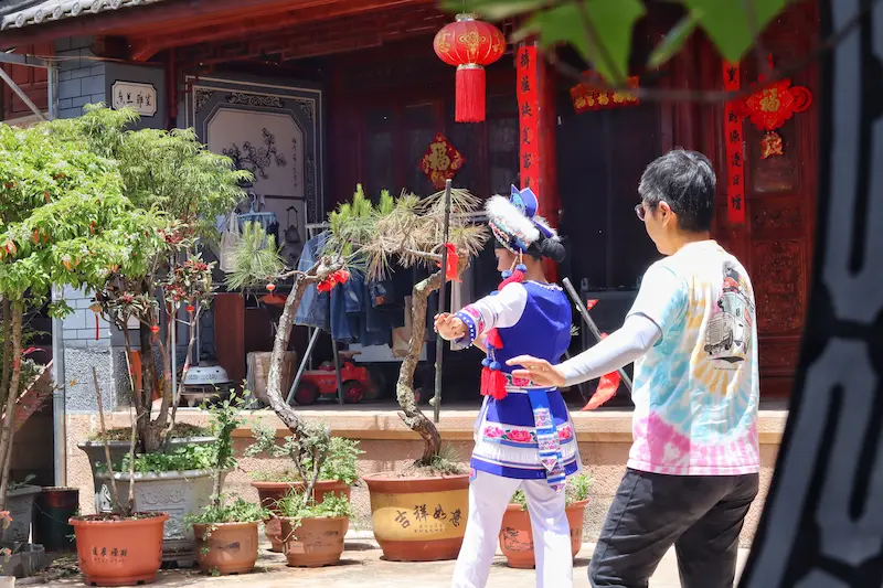 A Singaporean guest learning the Bai rattlestick dance.