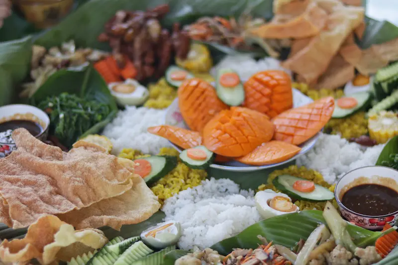 A Yunnan Dai-style hand-grabbed feast featuring a variety of dishes served on a single giant bamboo platter.
