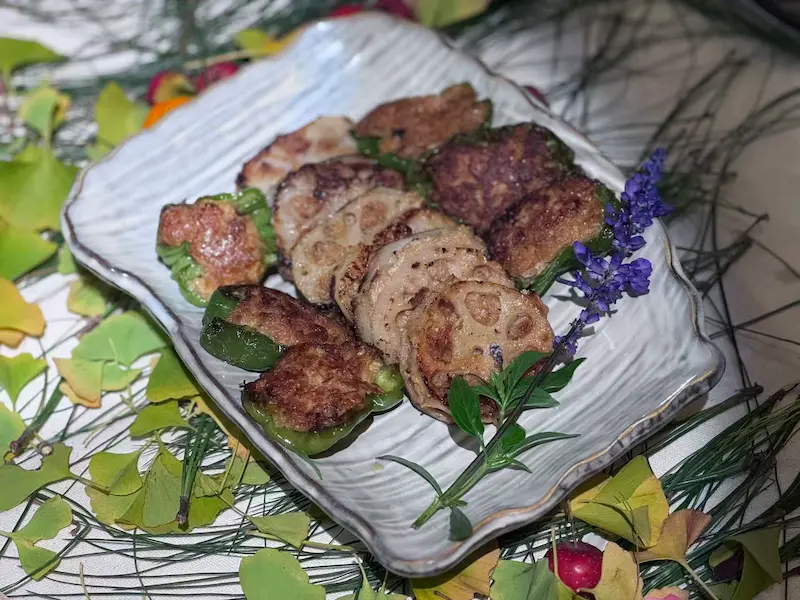 A fine-dining plant-based dish of lotus root stuffed with assorted ingredients.