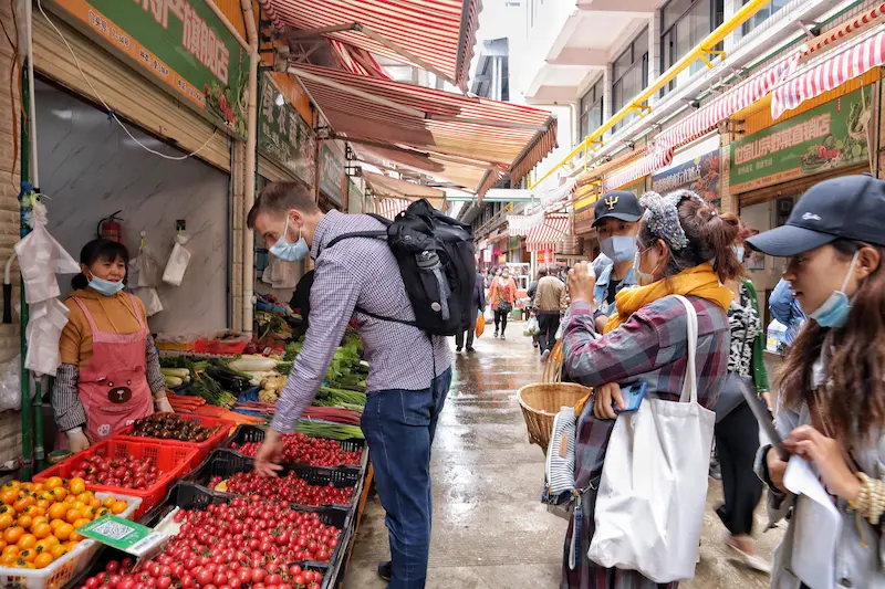 A group of guests looking at produce at a local market in Yunnan.
