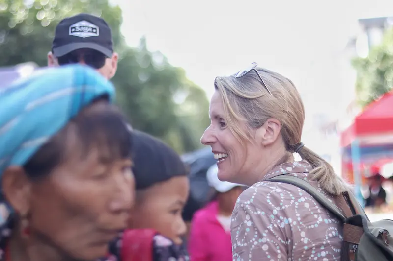 A guest smiling and browsing a Yunnan ethnic minority farmers’ market.