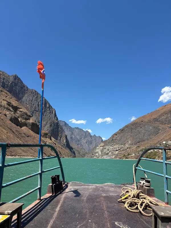 Boat ride on the turquoise Jinsha River through dramatic canyon walls near Stone Village, Lijiang, Yunnan