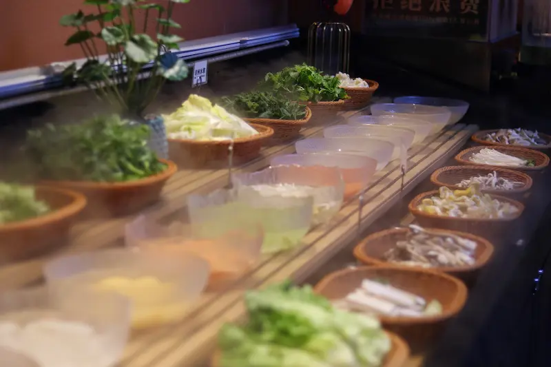Dozens of ingredients displayed on the counter at a wild mushroom hotpot restaurant.