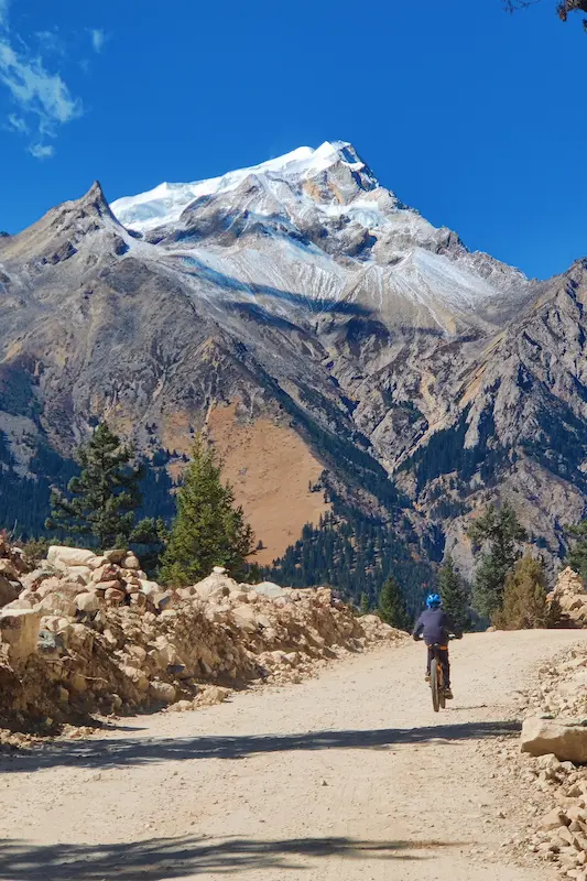 Electric mountain biking on a dirt road toward Jade Dragon Snow Mountain, Lijiang, Yunnan.