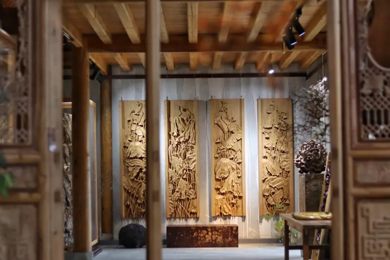 Four delicate wooden carvings hanging inside a wooden house.