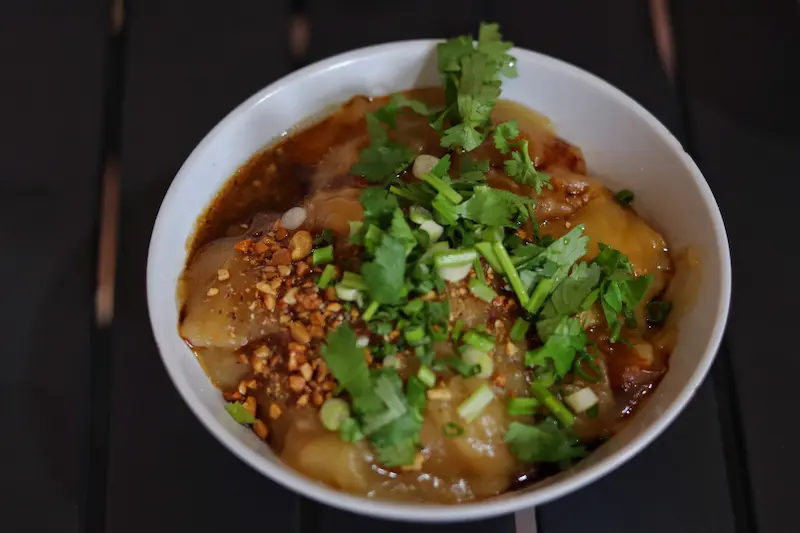 Hot yellow pea puree topped with cilantro, peanuts, and chili oil, a Weishan specialty in Yunnan.