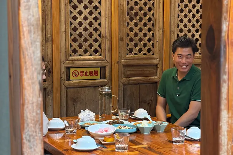 Kunming driver Cui smiling and enjoying a meal.