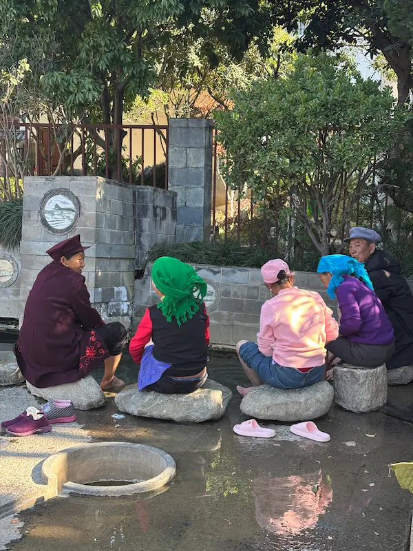 Locals gathering around a natural hot spring in a park, enjoying foot baths and conversation.