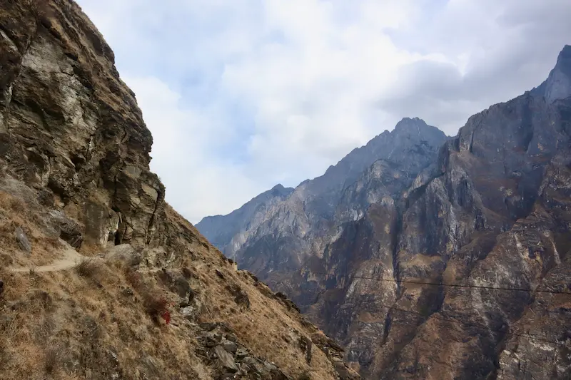The dramatic terrain of Tiger Leaping Gorge, with steep cliffside trails and rugged rocky mountains.