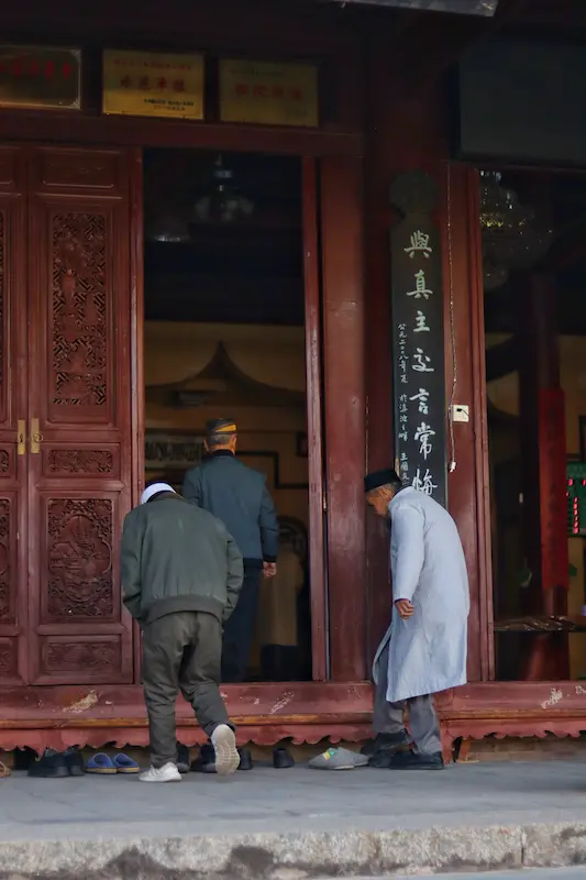 Three Hui Muslim men walking into a prayer hall for the next prayer.