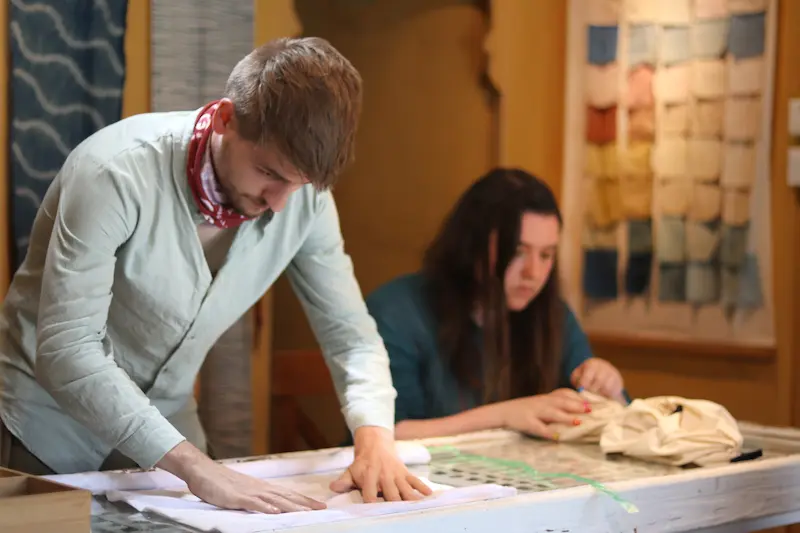 Two British guests designing patterns for their tie-dye pieces.