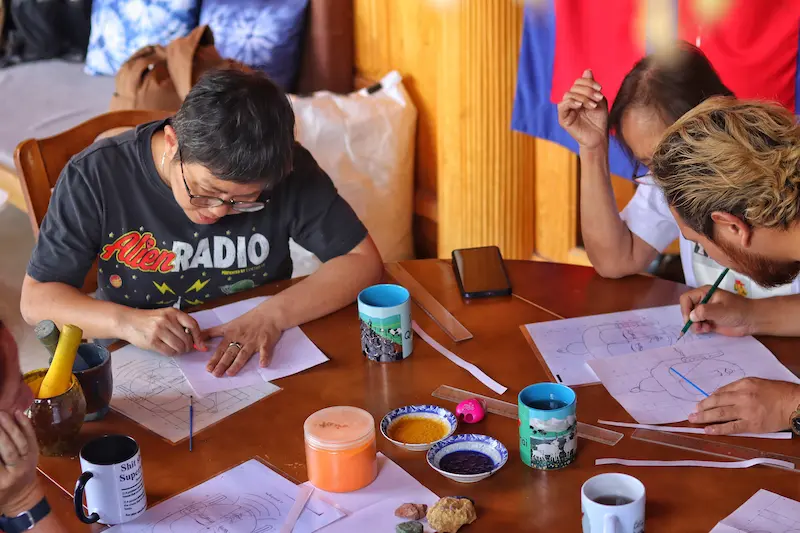 Two Singaporean guests taking part in a Tibetan Thangka painting workshop.