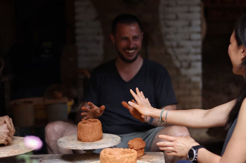 Visitors laughing during a hands-on pottery class in historic Jingtian Village, Dali, Yunnan.