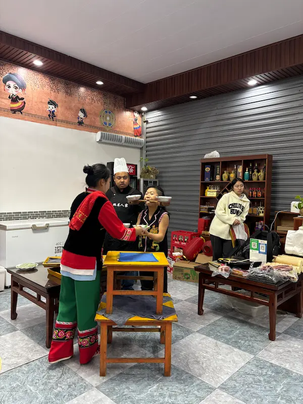 Yi minority performer balancing bowls on his chin during a traditional 'jumping dishes' act in Nanjian, Dali, Yunnan.
