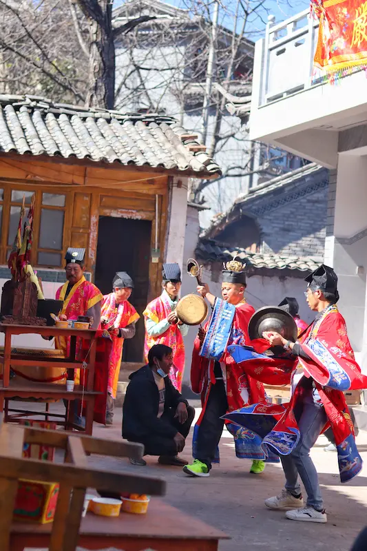 Yi villagers in traditional red and gold ceremonial dress performing a ritual in a Nanzhao royal descendant village, Dali, Yunnan.