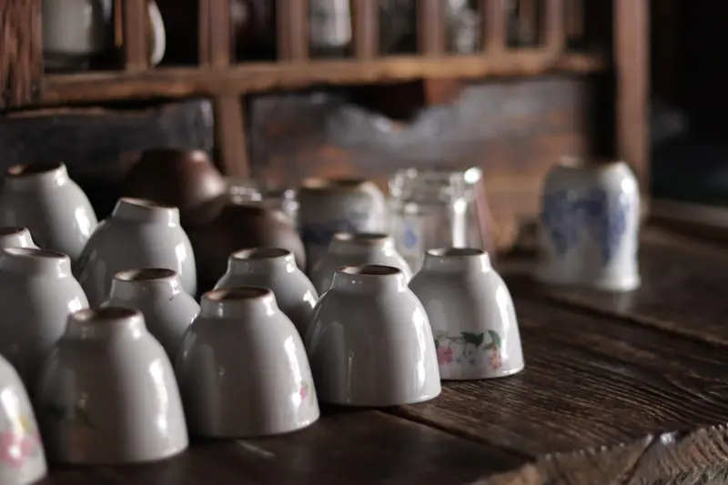 Rows of white ceramic teapots and cups at a century-old tea shop in Baoshan