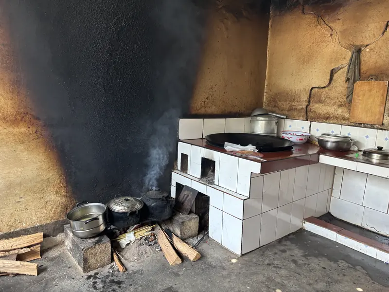 Cooking over a traditional wood-fired stove at a local tea family's home in Baoshan