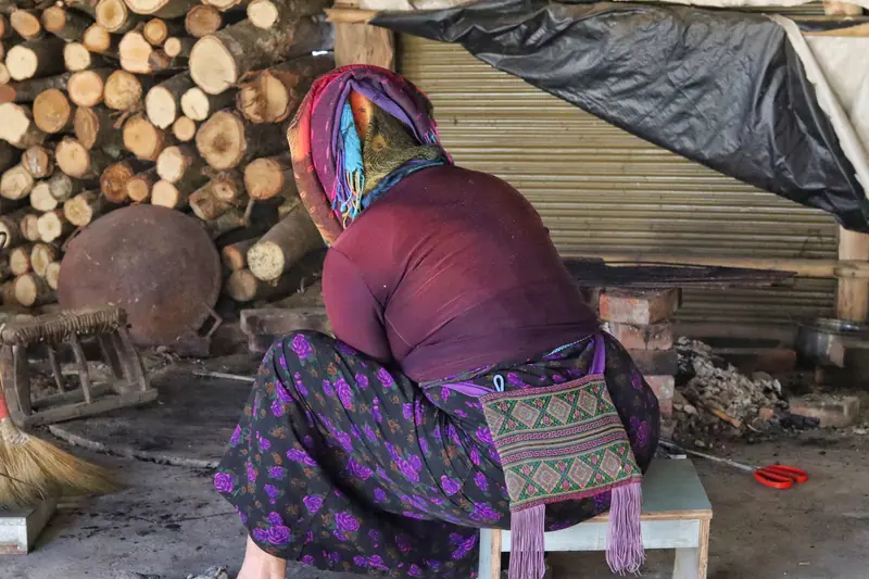 Pounding mulberry bark into pulp for traditional Dai papermaking
