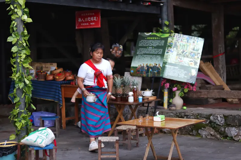 A De'ang woman in traditional dress at a village shop in Mangshi, Yunnan