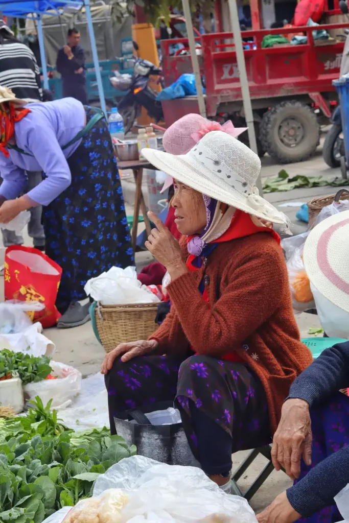 Vendors selling fresh vegetables at a Menghai ethnic market
