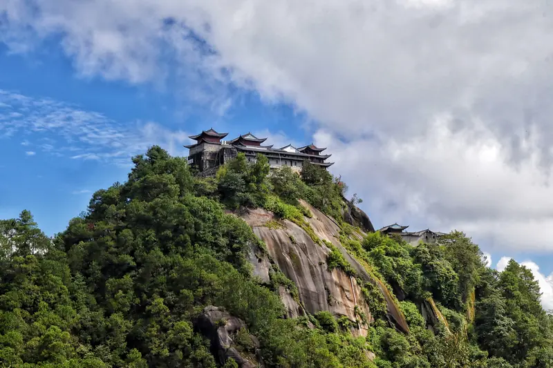 Ancient Daoist temple perched on a mist-covered mountain peak in Tengchong