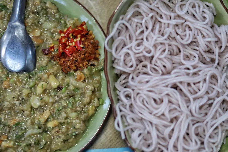 Traditional style purple rice noodles with mashed potato and chili dip in Yunnan