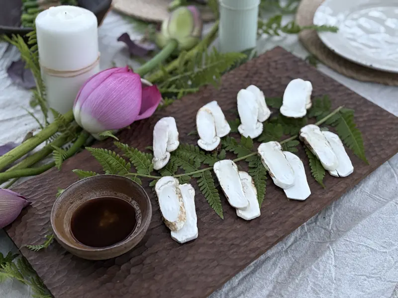 White vegan course arranged on leaves with a lotus flower centerpiece, Yunnan farm-to-table dinner
