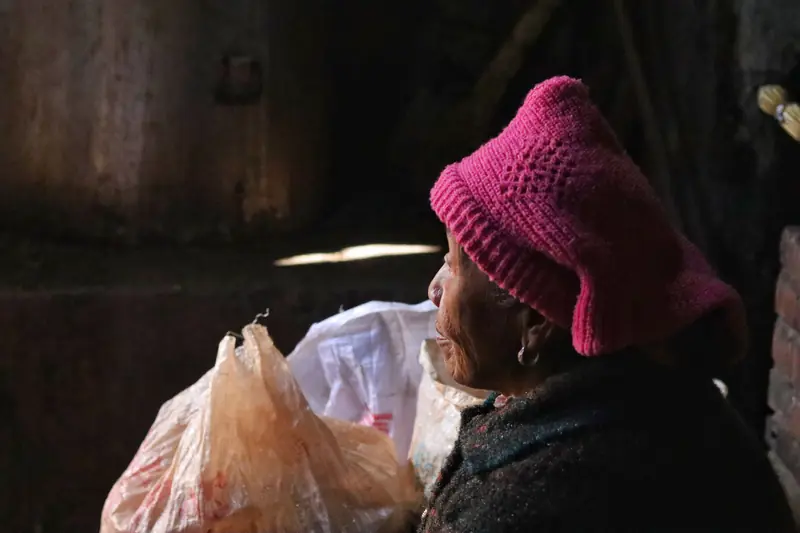 An elderly resident sits inside a fossil-stone house in the 500-year-old village.