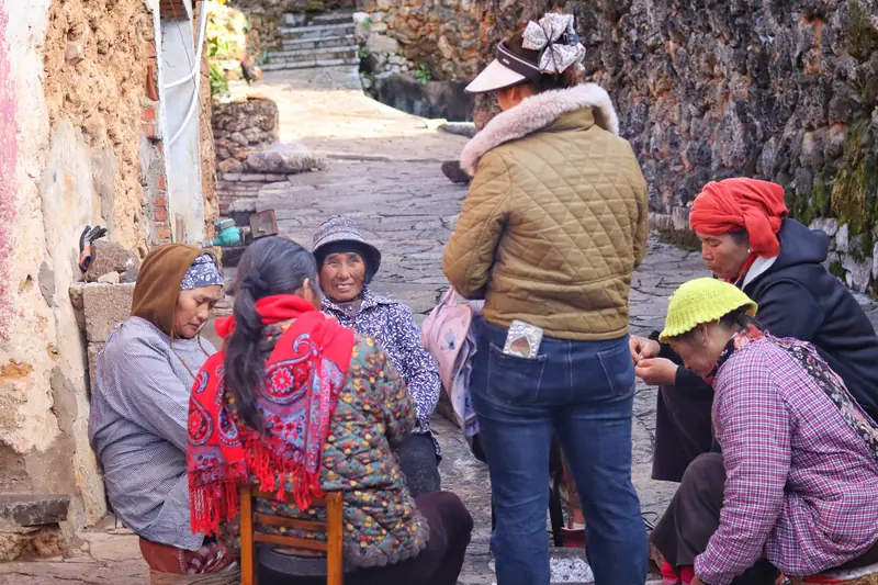 Villagers gather along a stone lane in the 500-year-old fossil-stone village.