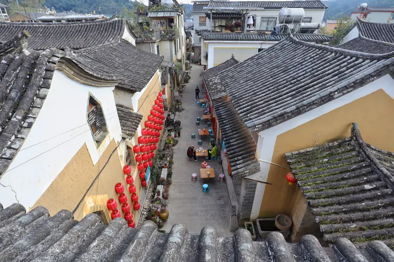 Rooftop view of a lantern-lined alley in the ancient Pu'er trading town.