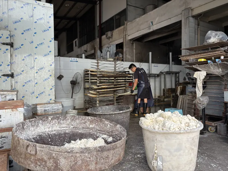 Tofu-making vats and drying racks inside a Shiping tofu workshop.