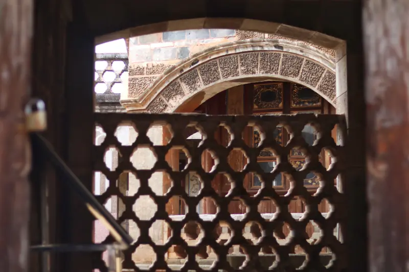Ornate carved wooden lattice window on a century-old courtyard house in Tonghai.