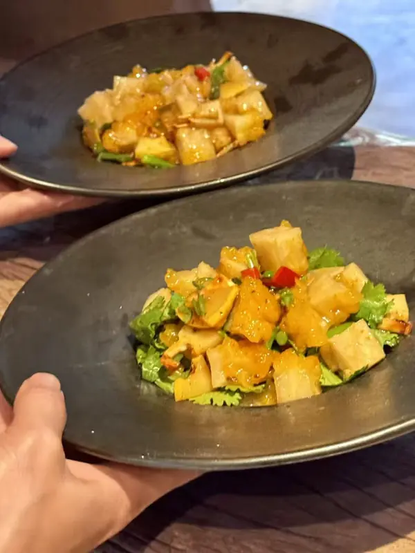 Diced vegetable salad course being served, highlight from the Yunnan vegan fine dining tour