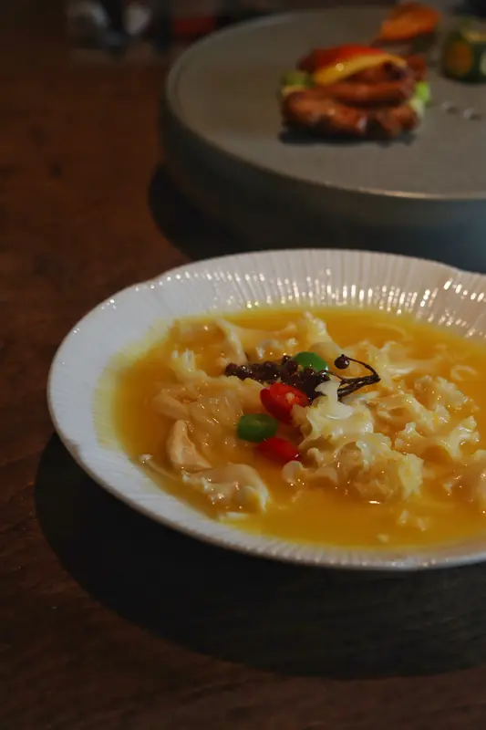 Vegan soup course with a folded garnish in broth, Yunnan fine dining restaurant