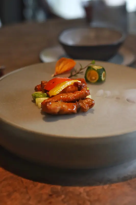 Seared vegan course with greens on ceramic plate, Yunnan fine dining tasting menu