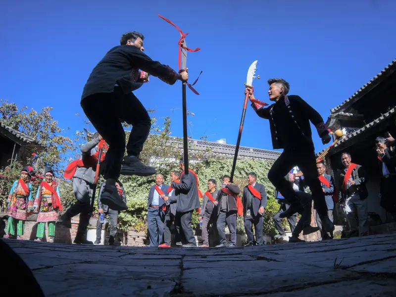 Yi minority performers in traditional dance with props, Yunnan
