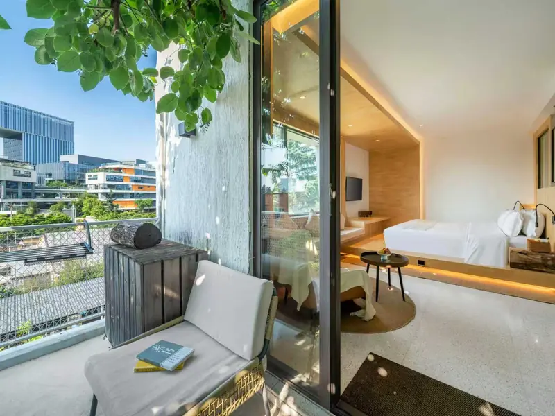 Hotel room balcony with seating and city view, Yunnan eco tour accommodation