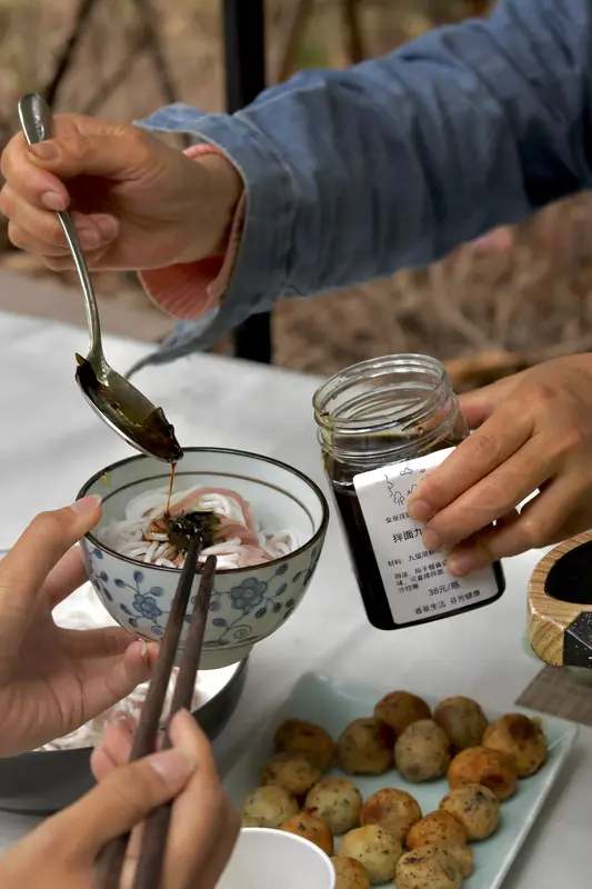 Tasting fried bites with dipping sauce in a Yunnan herb garden