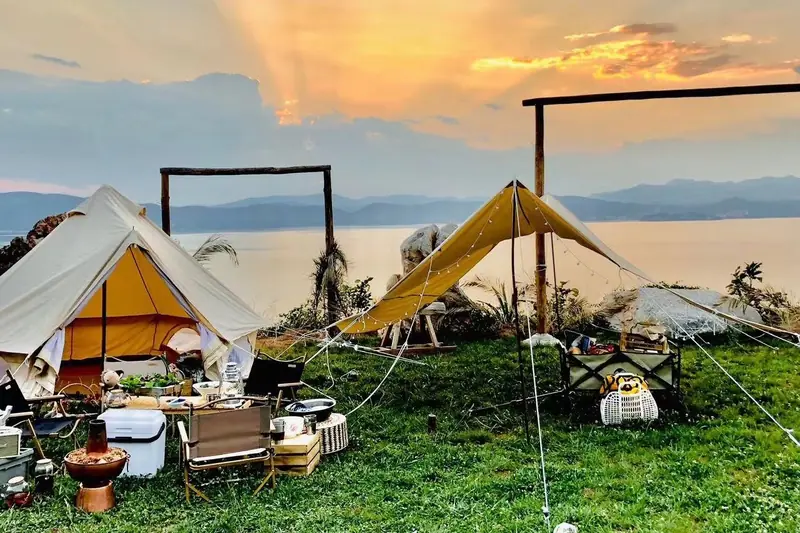 Glamping tents set up lakeside at sunset on a Yunnan organic farm