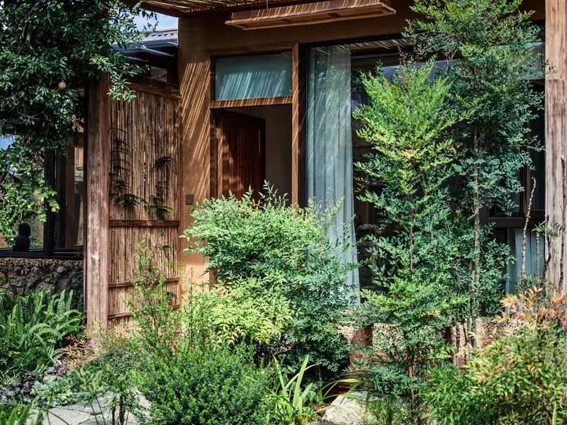 Wooden exterior of a vegan homestay surrounded by greenery in Yunnan
