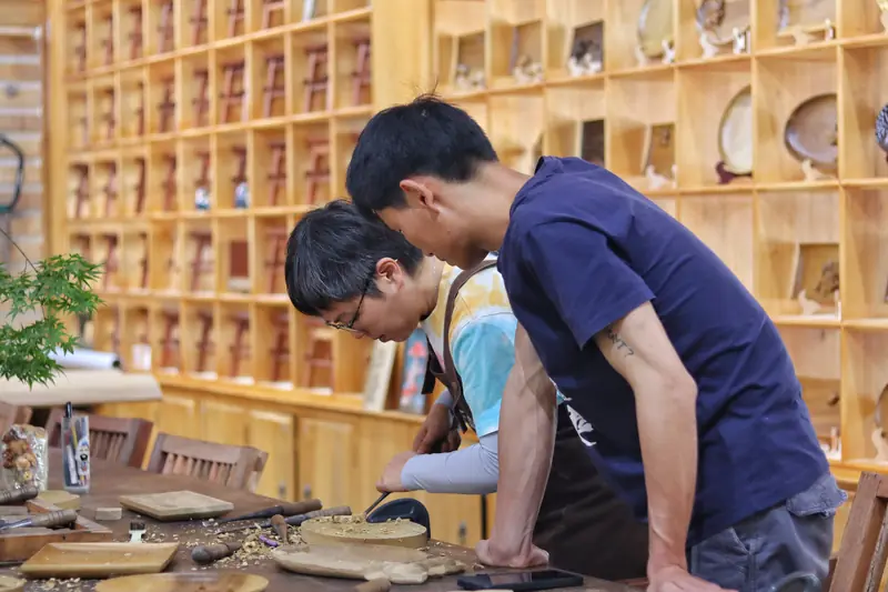 Local artisans working at a wood carving bench in Yunnan